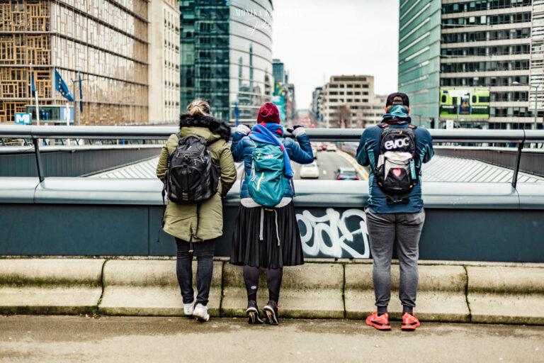 Trzy osoby na moście, widok miasta.